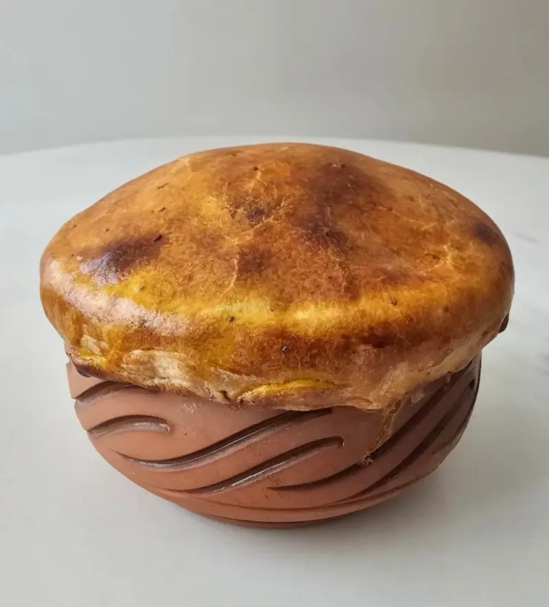 A clay handi sealed with a golden dough crust